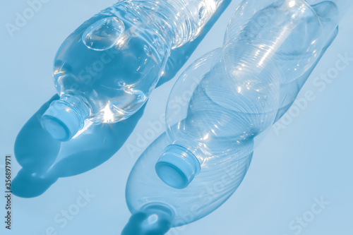 Two plastic bottles on a blue background.