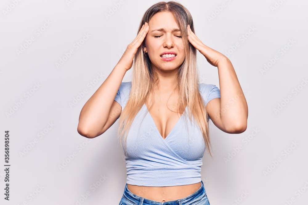 Young blonde woman wearing casual clothes with hand on head, headache because stress. suffering migraine. Young blonde woman wearing casual clothes with hand on head, headache because stress. suffering migraine.