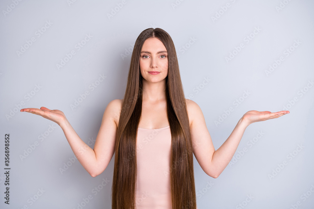 Portrait of her she nice attractive pretty confident well-groomed brown-haired girl holding on palms copy empty blank space place advert isolated on light gray pastel color background