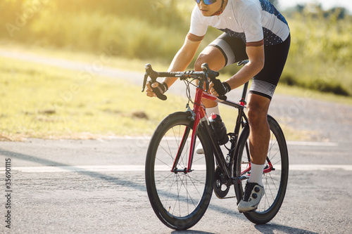 Man cyclist legs riding Mountain Bike on highway sun set , hi key