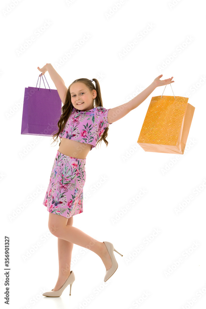 Fototapeta premium Little girl with multi-colored bags in their hands.
