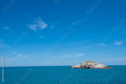 Small island on the blue sky background