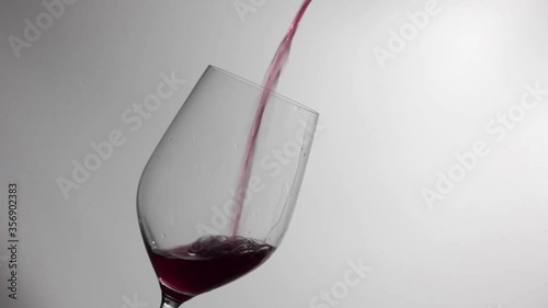 Filling a wine glass with red wine