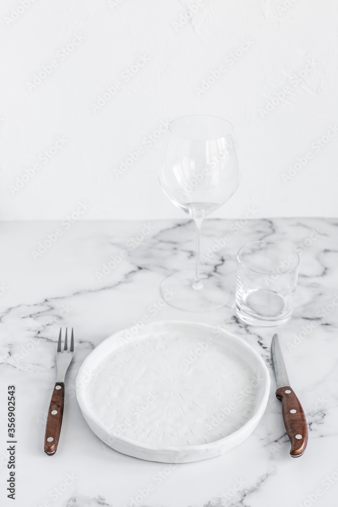 Stylish elegant table setting with ceramic plate on white marble background