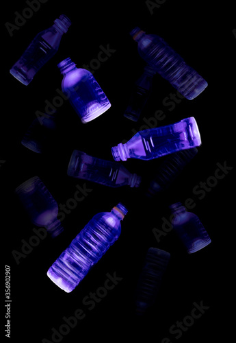 Falling recycle water bottles in motion abstract on black (ID: 356902907)