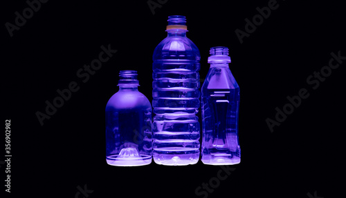 Purple illumination of clear plastic recyclable water bottle
