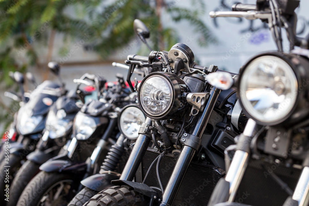 Horizontal close-up detail of many brand-new motorcycles parked in a row, in a motorbike dealership. Several bikes for sale Horizontal close-up detail of many brand-new motorcycles parked in a row, in a motorbike dealership. Several bikes for sale