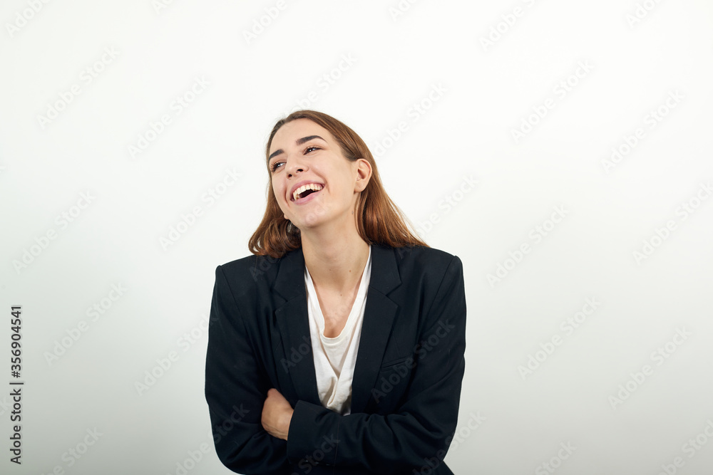 Arms crossed, laughing looking at camera with big grin. Happy face smiling. Positive person. Young attractive woman brown hair in a light t-shirt and black jacket on white background Arms crossed, laughing looking at camera with big grin. Happy face smiling. Positive person. Young attractive woman brown hair in a light t-shirt and black jacket on white background
