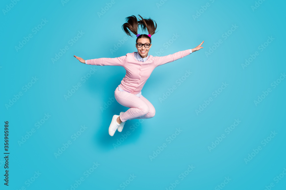 Full size photo of cheerful high school student girl jump hold hand imagine she fly plane academic lesson wear pink clothes sneakers isolated over blue color background