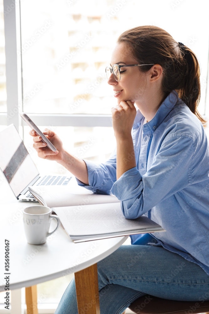 Attractive young woman sitting at the kitchen table Attractive young woman sitting at the kitchen table