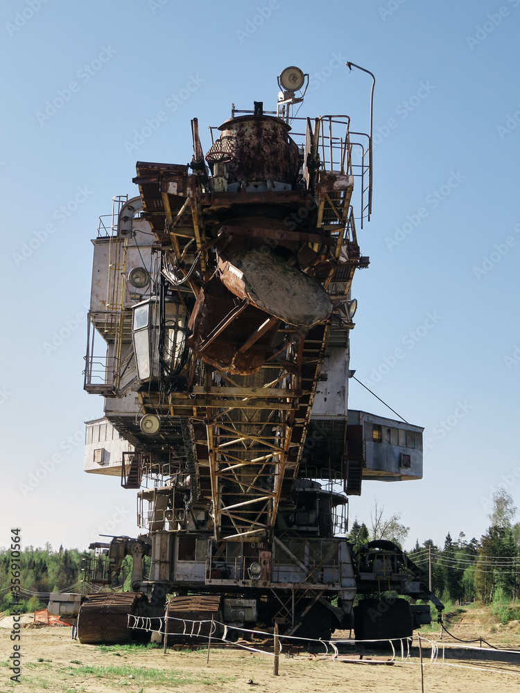 Giant old absetzer rusts in a sand quarry. Huge mining excavator.