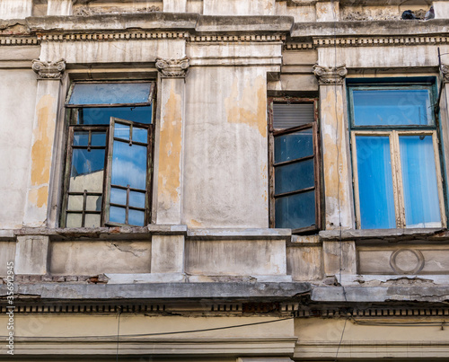 Detail of an worn out old building with windows in the center of Bucharest.