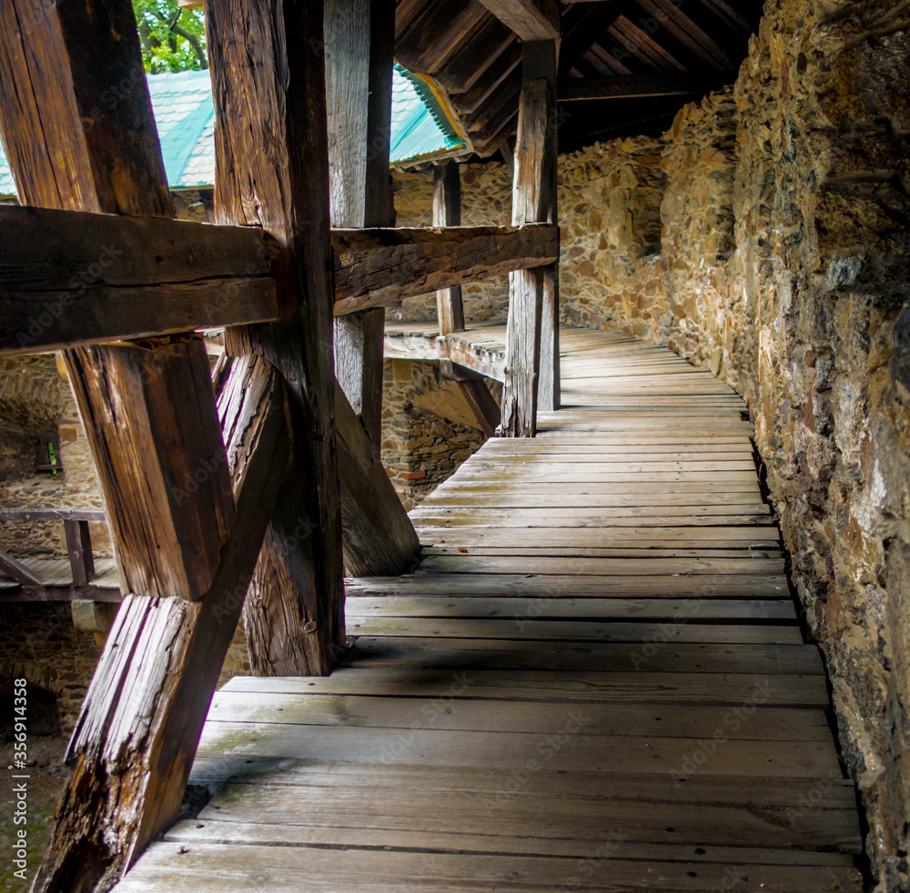 Walking along the floor from boards in the courtyard of an ancient castle Walking along the floor from boards in the courtyard of an ancient castle