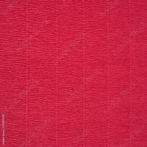 Crepe crinkled Paper texture in pinky red, abstract background
