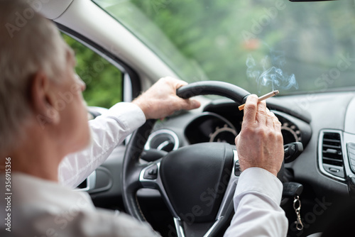 Man smoking a cigarette while driving
