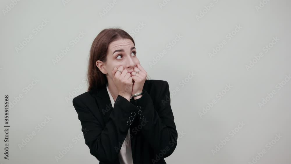 Image of scared, biting fists emotionally. Covering mouth behind knuckle. Having fear. Nervous frightened keeps hand near face, worried expression. Anxious unshaven feels depressed. Attractive woman Image of scared, biting fists emotionally. Covering mouth behind knuckle. Having fear. Nervous frightened keeps hand near face, worried expression. Anxious unshaven feels depressed. Attractive woman