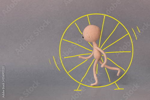 A toy man on a gray background with copy space. Presentation PowerPoint or Keynote. Motivational phrase. A sketch is drawn on top of the photo.Man running in a wheel