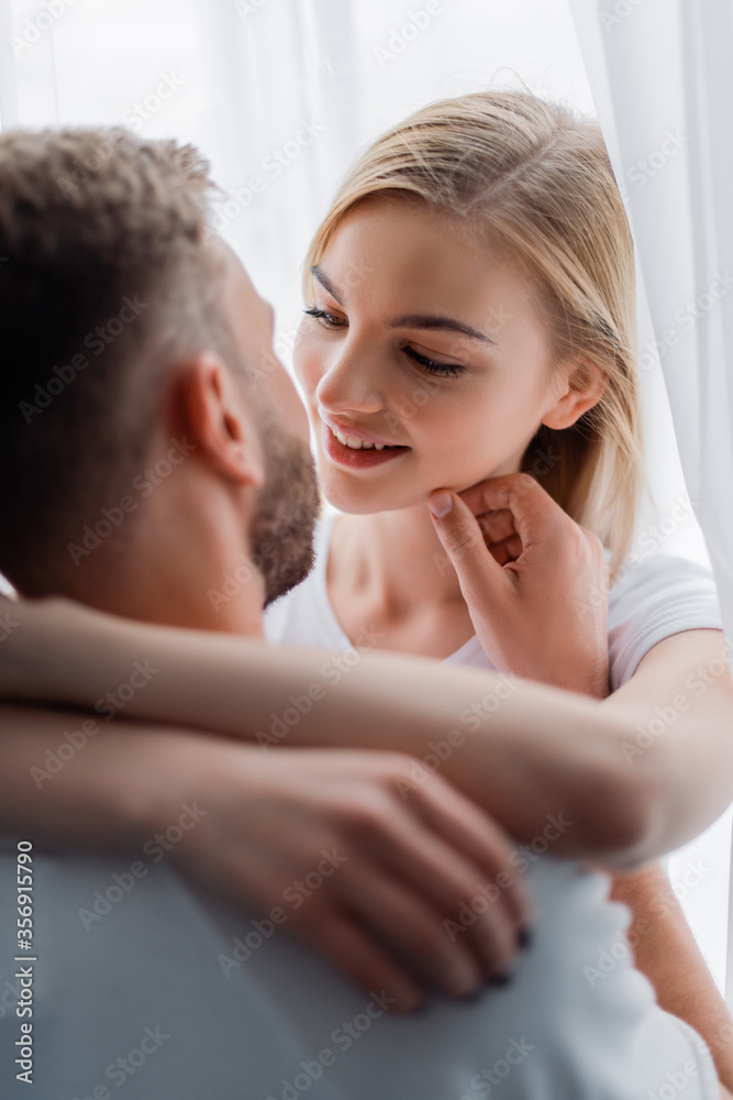 selective focus of man touching face of smiling young woman selective focus of man touching face of smiling young woman