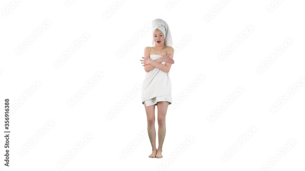 Young woman nude in towel freezing cold shivering and rubbing arms to warm up isolated on solid white background. Young woman nude in towel freezing cold shivering and rubbing arms to warm up isolated on solid white background.