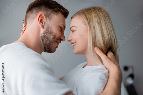 side view of cheerful couple smiling while looking at each other