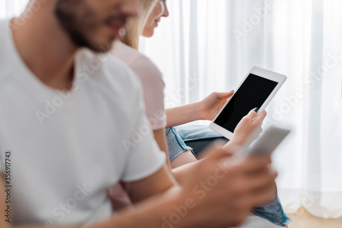 selective focus of happy woman holding digital tablet with blank screen near boyfriend © LIGHTFIELD STUDIOS