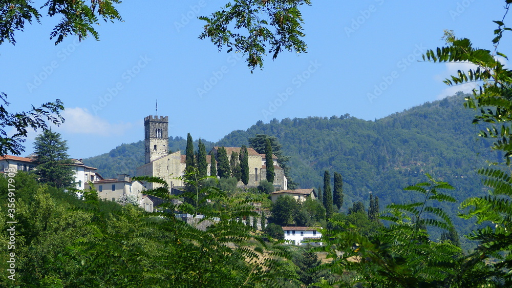 toskanisches Dorf auf einem Hügel umgeben von Wald und Wiesen toskanisches Dorf auf einem Hügel umgeben von Wald und Wiesen