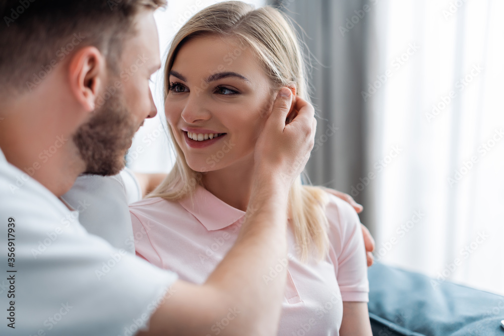 selective focus of bearded man touching hair of beautiful girlfriend selective focus of bearded man touching hair of beautiful girlfriend