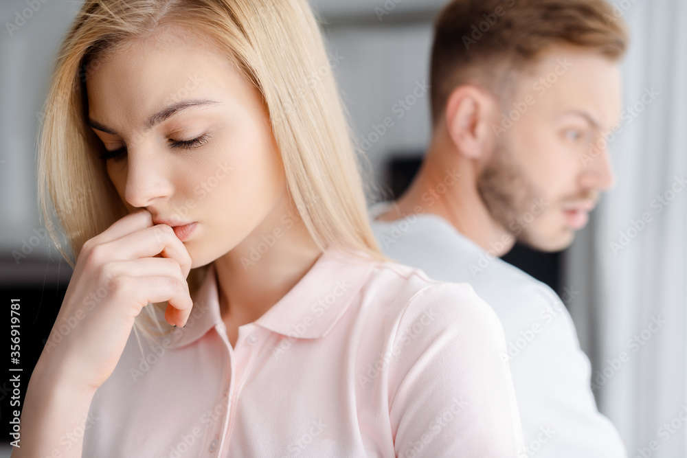 selective focus of upset girl standing near boyfriend, relationship difficulties concept selective focus of upset girl standing near boyfriend, relationship difficulties concept