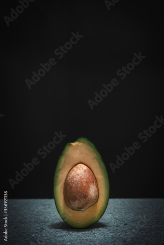 Halved avocado on black background with space for your text