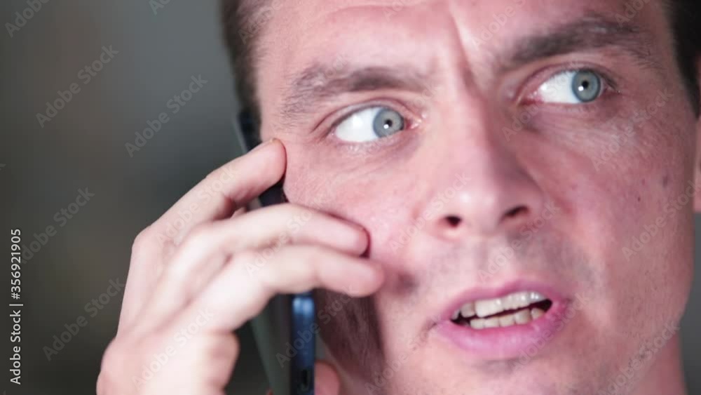 Close-up of an emotional man talking on the phone. Telecommunication of close people at a long distance. Close-up of an emotional man talking on the phone. Telecommunication of close people at a long distance.