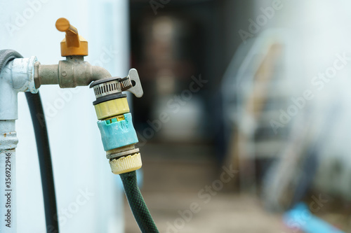 Hoses that connect to the faucet with an old connector at the back of the house