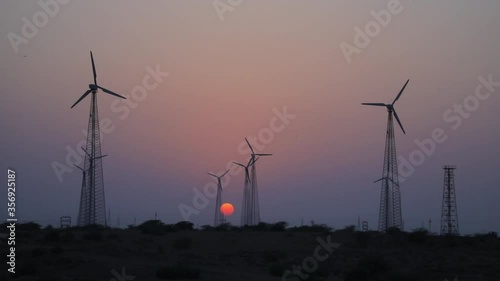 Wind turbine farm on beautiful golden hour evening mountain landscape. Renewable energy production for green ecological world beautiful purple evening mountain landscape