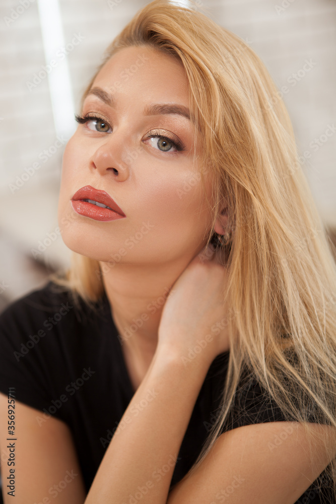 Vertical close up of a gorgeous woman with long blond hair looking to the camera sensually Vertical close up of a gorgeous woman with long blond hair looking to the camera sensually