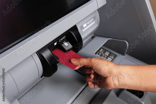Female Hand Inserting Credit Card in an ATM Machine To Transfer Money or Withdraw Cash. Close Up. a card being swiped. ATM Transaction. 