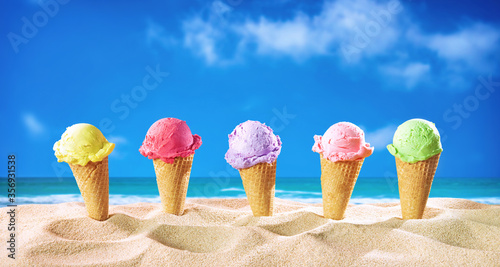 Ice creams cones and seashells in the sand on the beach