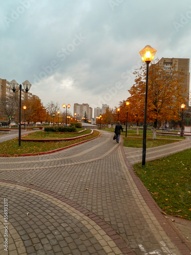 A city Park with sparse yellow trees and burning lanterns © Kseniya