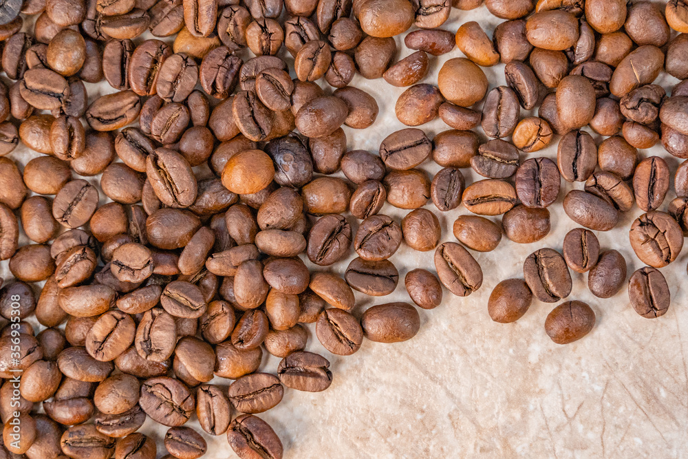 sprinkled roasted coffee beans on white and yellow marble top view sprinkled roasted coffee beans on white and yellow marble top view