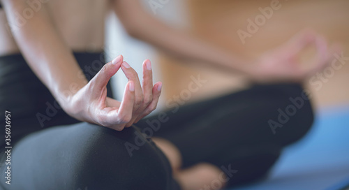Closeup woman hand meditating in the lotus pose at home.