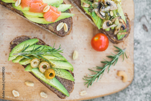 avocado sandwich with vegetables served on wooden plate, side view, isolated, healthy lifestyle