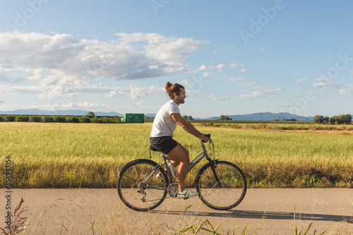Young man on a bicycle on a country road