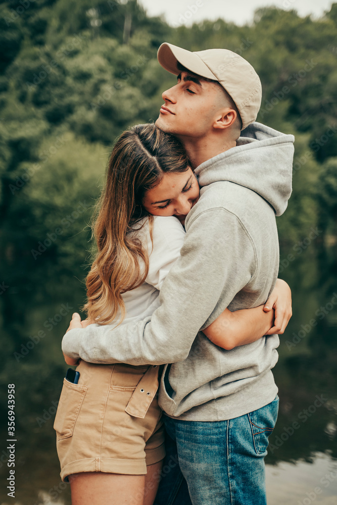 Fototapeta premium Young couple hugging in a natural lake.