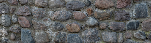 Close Up of wall of granite boulders. panorama of a stone wall. vintage background.