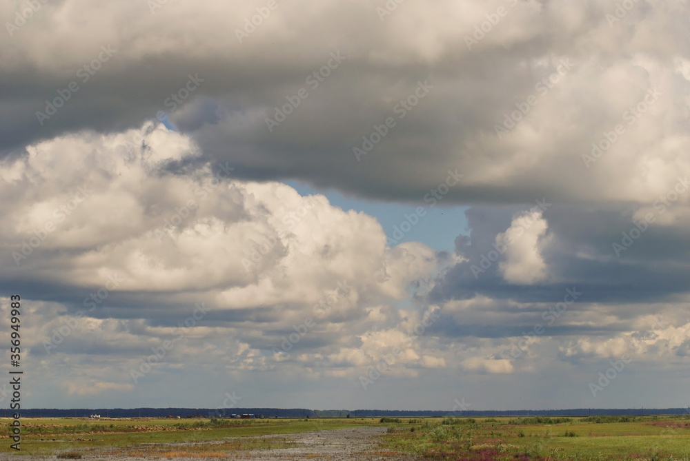 Low Cumulus cloud cover over the water meadow. Khanty-Mansiysk. Western Siberia. Russia. Low Cumulus cloud cover over the water meadow. Khanty-Mansiysk. Western Siberia. Russia.