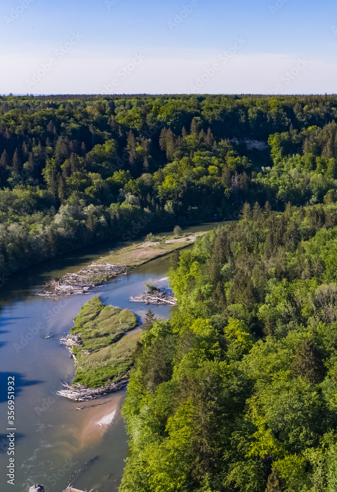 River flow through german forest seen from above bird view. Spring time for the Isar river flowing to Munich.