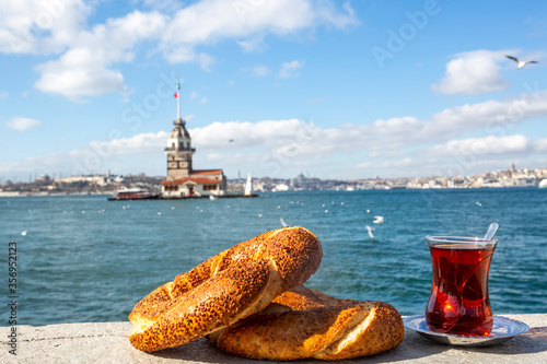 A glass of Turkish tea and bagel against Maidens Tower on sea in Istanbul, Turkey