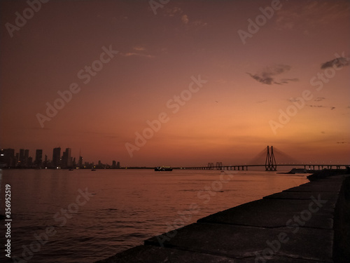 Fototapeta Naklejka Na Ścianę i Meble -  Bandra worli sea-link bridge in sea at Bandra, Mumbai with Mumbai's skyline behind it.