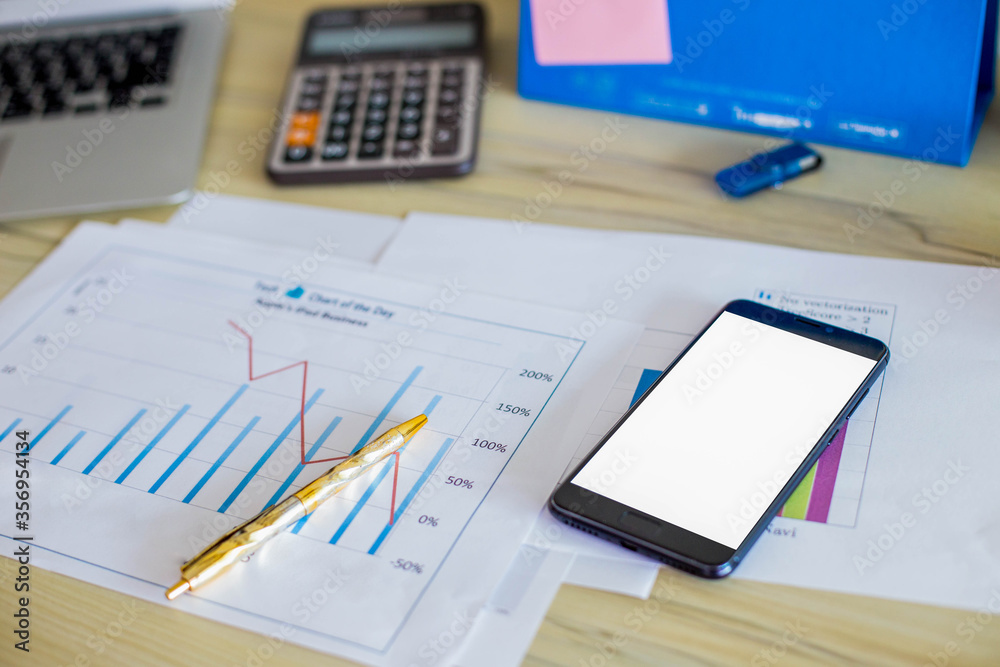 Blank screen with phone with graphs and charts on the table.