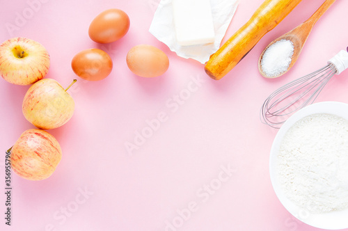 Frame of food ingredients on a pastel pink background. The concept of baking apple pie. Top view, copy space for text.