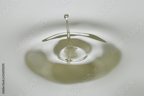 Foto Dripping colorless oil on white background.