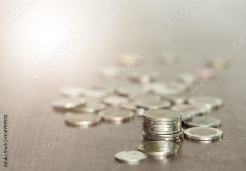 The close-up rows of money coins on desk with a blurred background